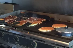 Pancakes, hash browns and bacon cooking on the Uptowner griddle