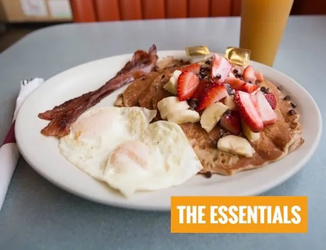 Pancakes with strawberries and bananas, eggs and bacon – The Essentials breakfast